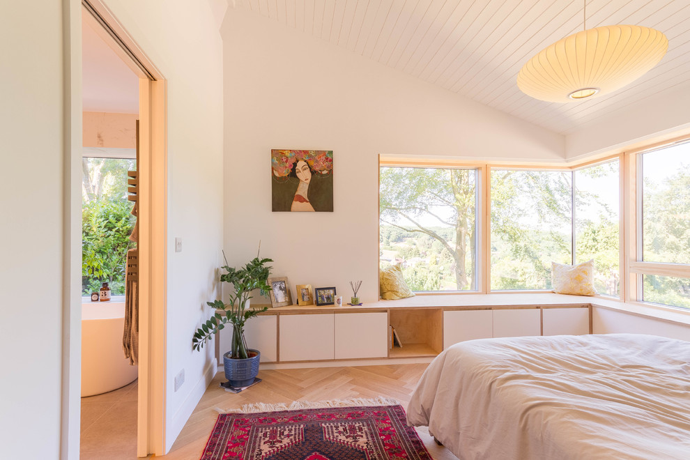 Idéer för ett mellanstort minimalistiskt sovrum, med ljust trägolv, beiget golv och vita väggar