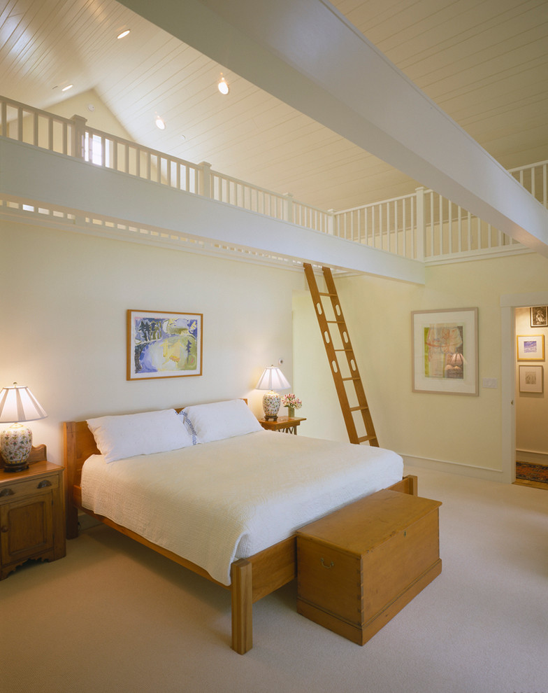 Immagine di un'In mansarda camera da letto tradizionale con pareti gialle
