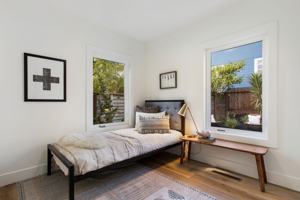 На фото: маленькая гостевая спальня (комната для гостей) в скандинавском стиле с белыми стенами и светлым паркетным полом для на участке и в саду