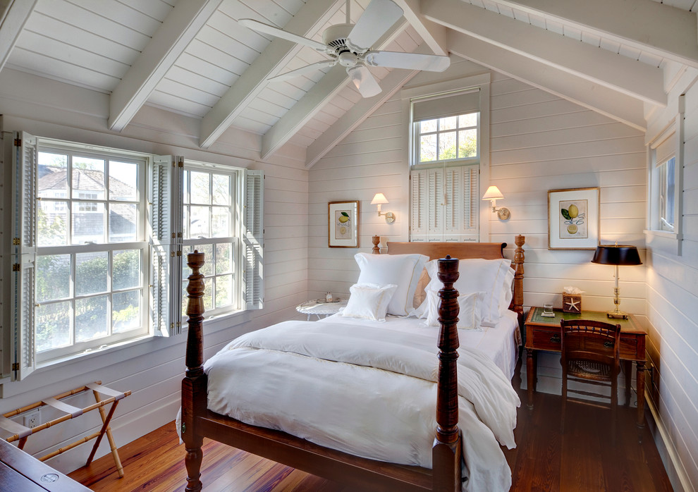 Modelo de dormitorio costero con paredes blancas, suelo de madera en tonos medios y techo inclinado