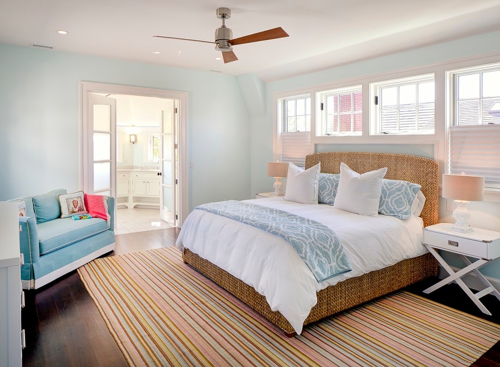 Imagen de dormitorio principal costero de tamaño medio con paredes azules y suelo de madera oscura