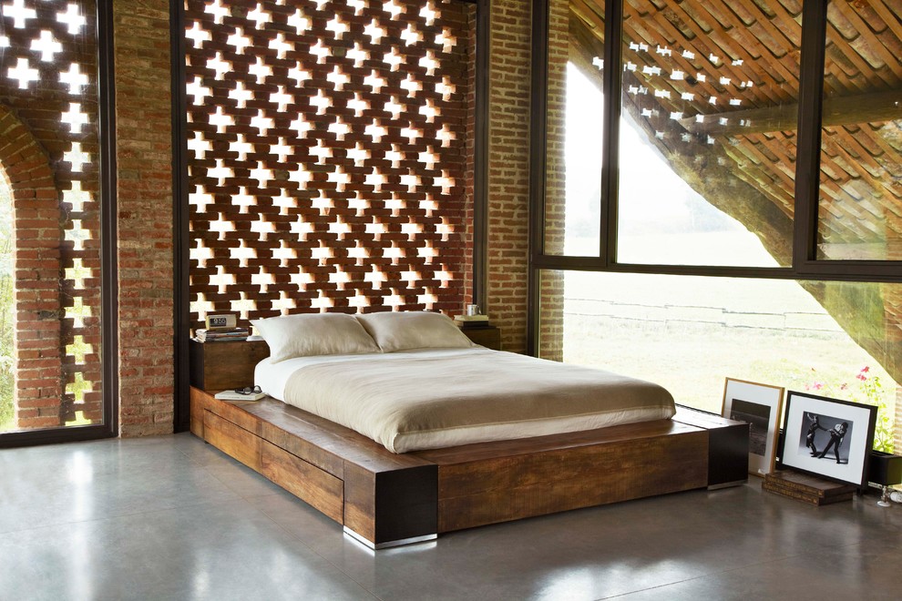 Esempio di una camera da letto contemporanea con pavimento in cemento