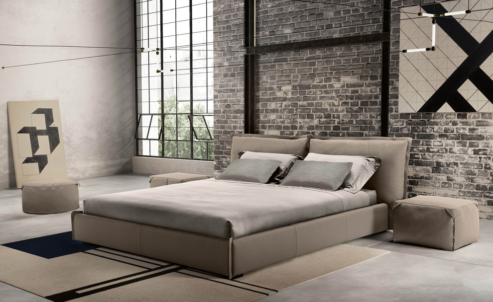 Foto på ett stort industriellt sovloft, med grå väggar, betonggolv och grått golv
