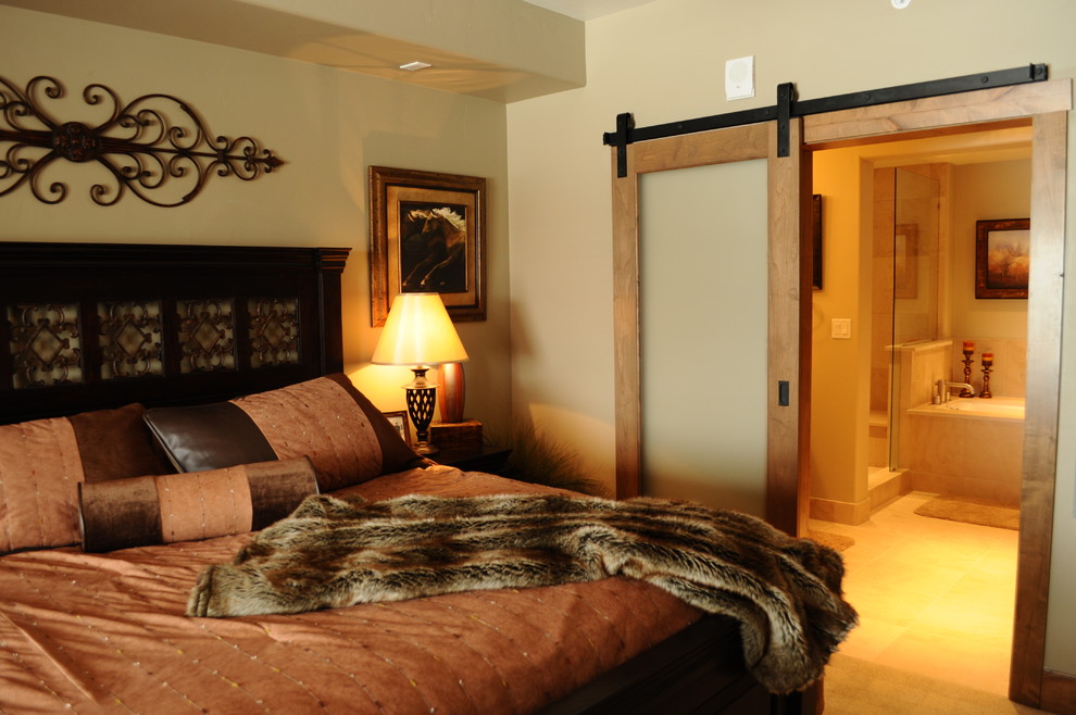 Modelo de dormitorio principal rural de tamaño medio con paredes beige y moqueta