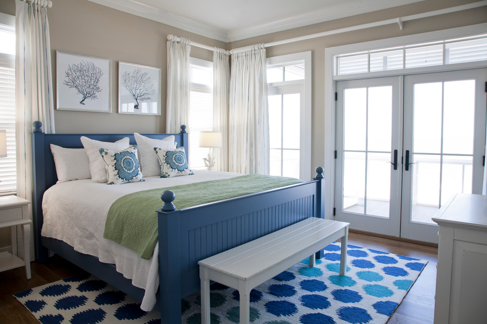 Foto de dormitorio principal costero con paredes beige y suelo de madera en tonos medios