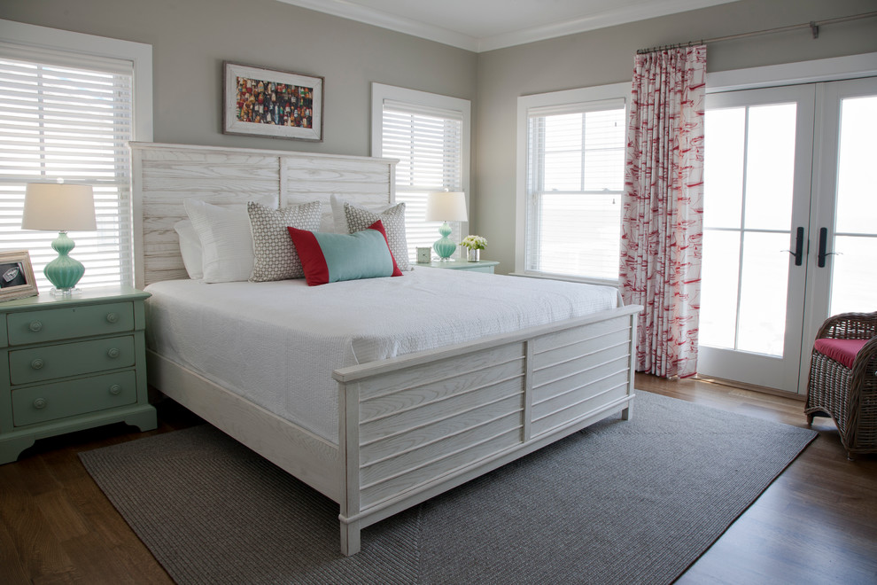 Large coastal master bedroom in Charleston with grey walls and dark hardwood flooring.