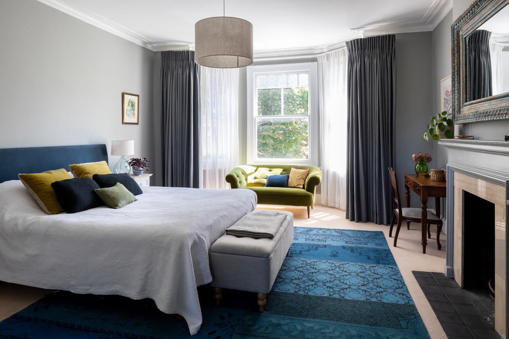 Classic master bedroom in London with grey walls, carpet, beige floors and a standard fireplace.