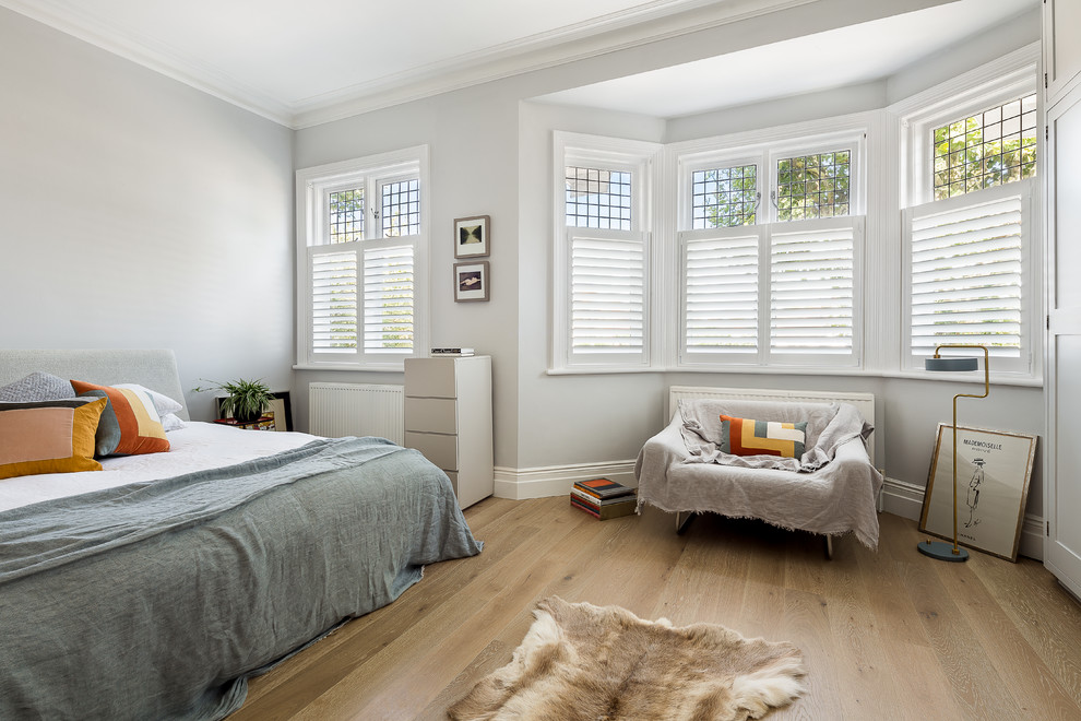 На фото: спальня в скандинавском стиле с серыми стенами и светлым паркетным полом с