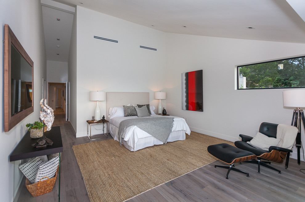 This is an example of a contemporary master bedroom in Los Angeles with white walls, light hardwood flooring and no fireplace.