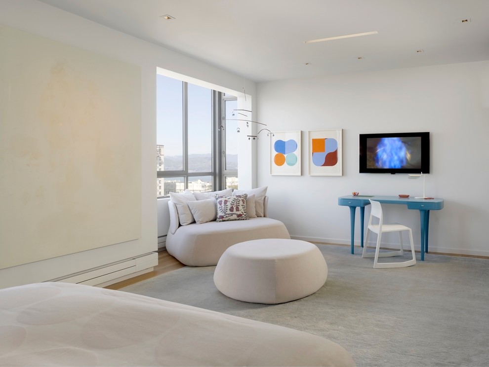 Imagen de dormitorio principal y televisión moderno extra grande sin chimenea con paredes blancas y suelo de madera clara