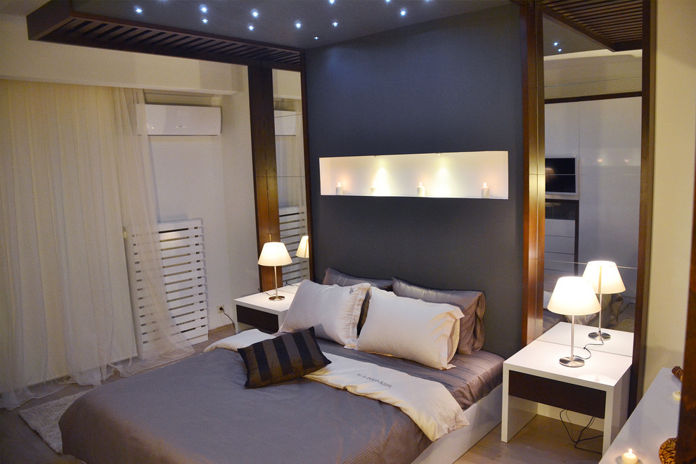 Foto de dormitorio principal minimalista de tamaño medio sin chimenea con paredes beige, suelo laminado y suelo multicolor