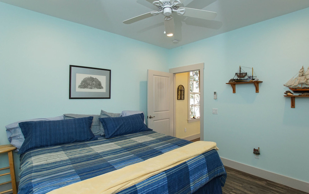 Diseño de habitación de invitados marinera grande sin chimenea con paredes azules y suelo de madera oscura
