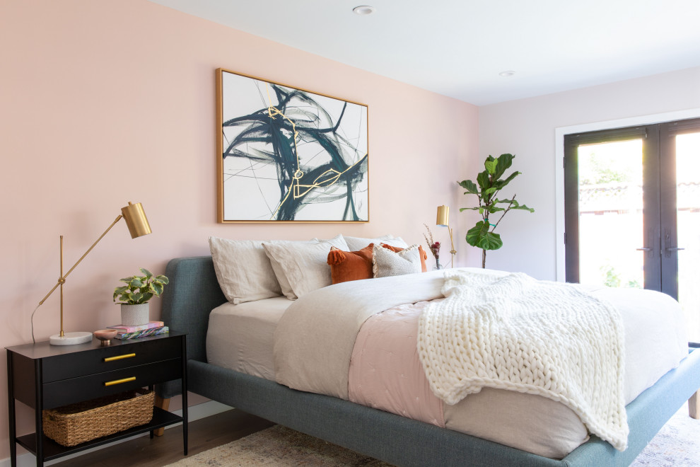 Cette image montre une chambre parentale vintage de taille moyenne avec un mur rose, un sol en bois brun et un sol marron.