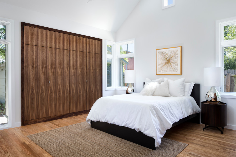 Идея дизайна: большая хозяйская спальня в современном стиле с белыми стенами, паркетным полом среднего тона и коричневым полом без камина