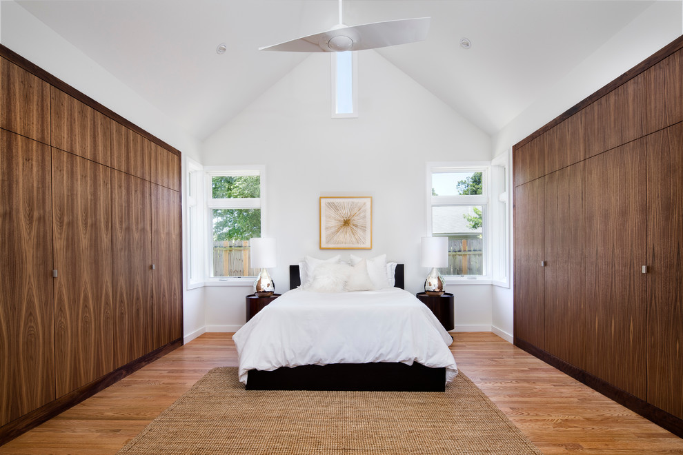 На фото: большая хозяйская спальня в современном стиле с белыми стенами, паркетным полом среднего тона и коричневым полом без камина