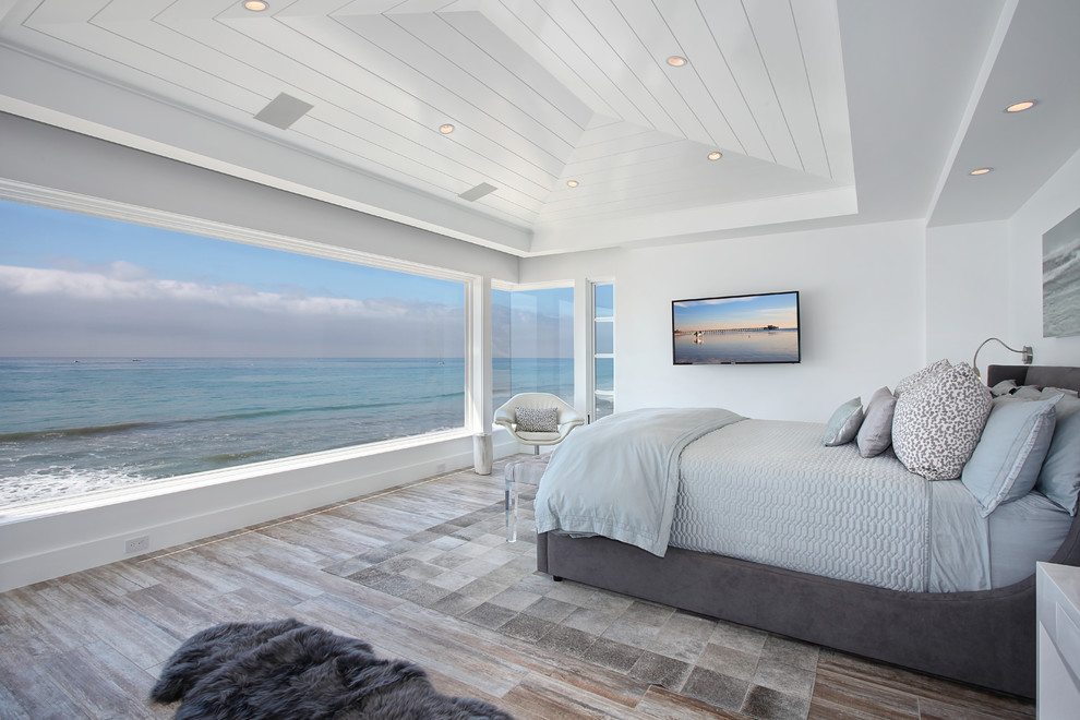 Exemple d'une chambre bord de mer avec un mur blanc et un sol en bois brun.