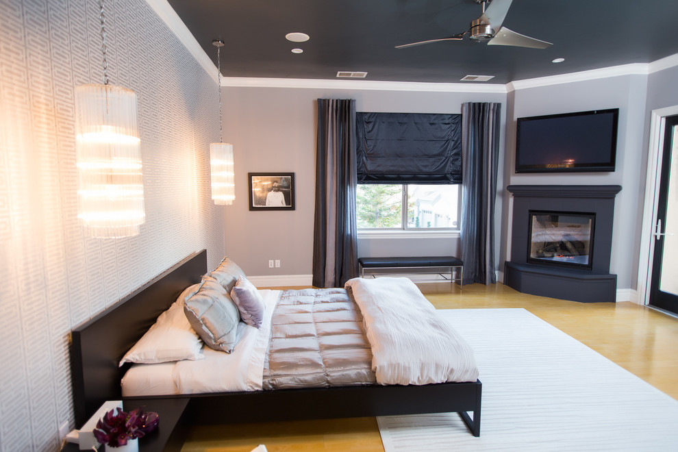 Modernes Hauptschlafzimmer mit grauer Wandfarbe, Eckkamin und hellem Holzboden in Sacramento