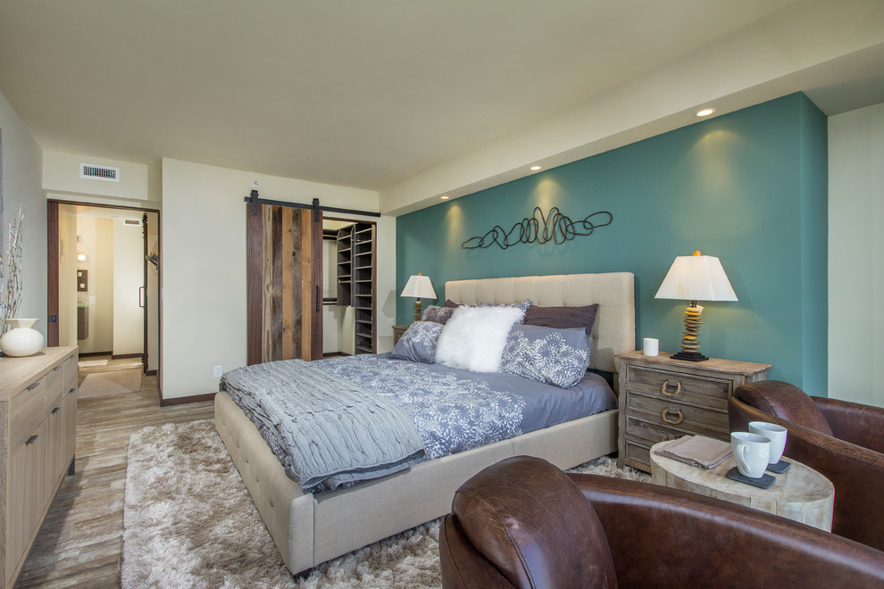 Inspiration för ett maritimt sovrum, med blå väggar och mellanmörkt trägolv