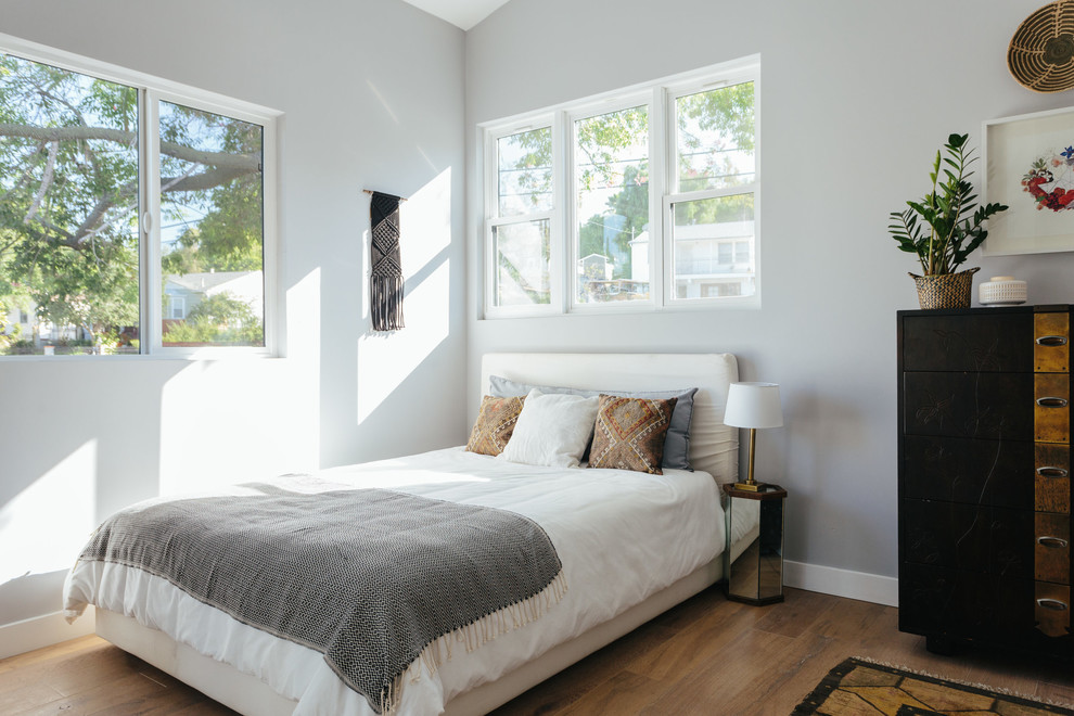 Modernes Schlafzimmer ohne Kamin mit grauer Wandfarbe und hellem Holzboden in Los Angeles