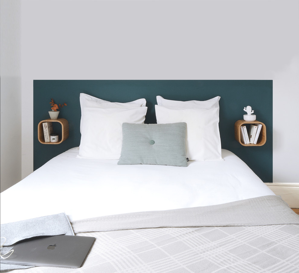 Ejemplo de dormitorio minimalista con paredes azules y suelo de madera en tonos medios
