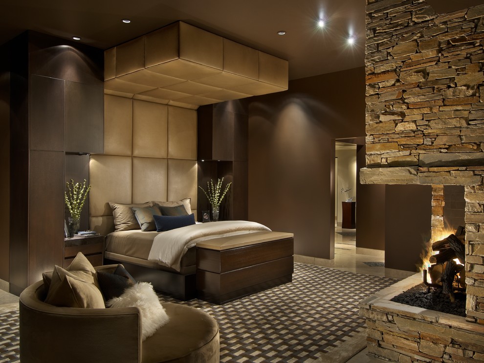 フェニックスにある広いコンテンポラリースタイルのおしゃれな主寝室 (茶色い壁、コーナー設置型暖炉、石材の暖炉まわり、カーペット敷き) のインテリア