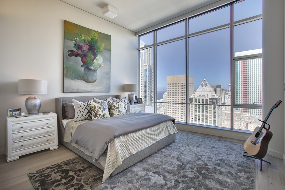 Imagen de dormitorio principal minimalista grande con paredes beige y suelo de madera en tonos medios