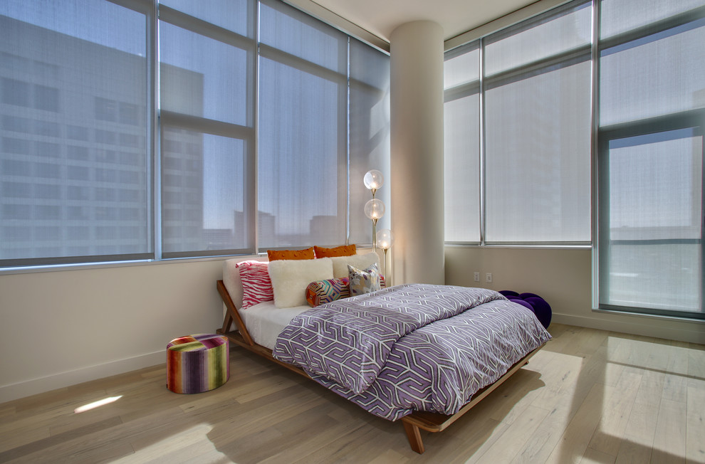 Inspiration pour une chambre d'amis minimaliste de taille moyenne avec un mur beige et un sol en bois brun.