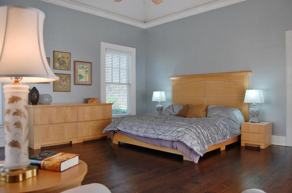 Idée de décoration pour une chambre parentale tradition de taille moyenne avec un mur bleu, parquet foncé et aucune cheminée.