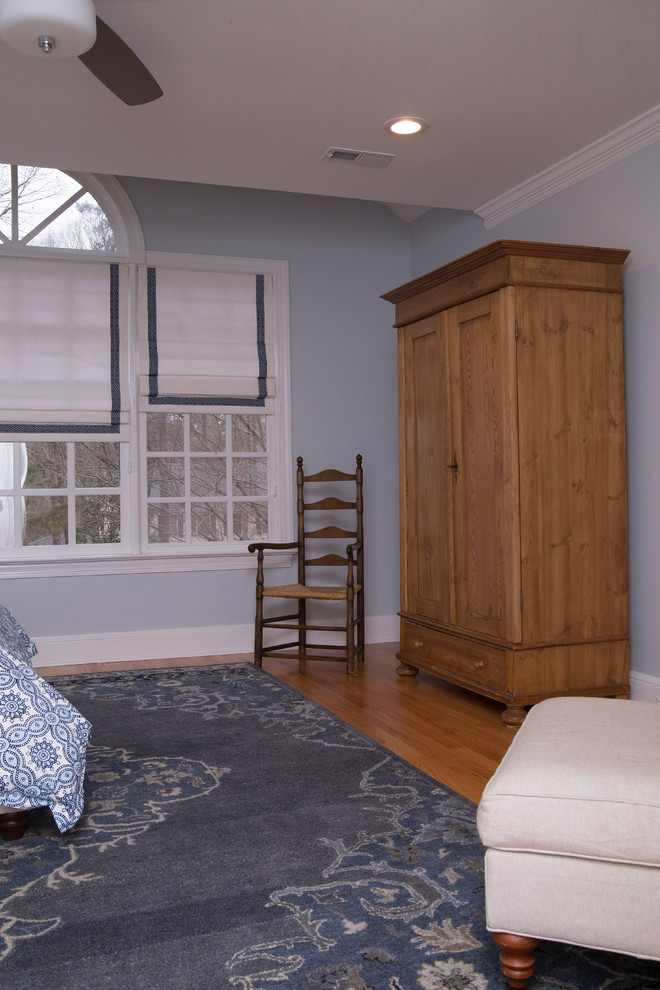 Foto de dormitorio principal clásico renovado grande con paredes grises, suelo de madera en tonos medios y suelo naranja