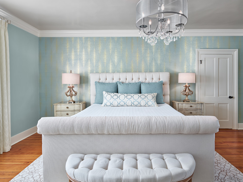 Immagine di una camera matrimoniale classica di medie dimensioni con pareti blu, pavimento in legno massello medio, camino classico, pavimento marrone e cornice del camino in pietra