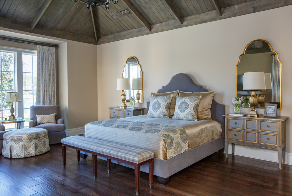 На фото: большая хозяйская спальня в классическом стиле с бежевыми стенами, темным паркетным полом и коричневым полом без камина с