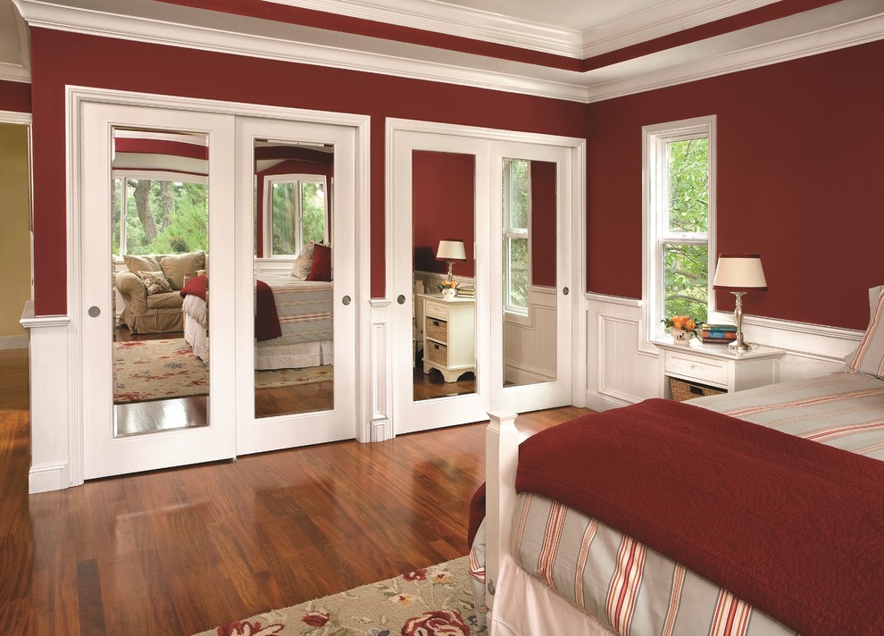 Diseño de dormitorio tradicional renovado con paredes rojas y suelo de madera en tonos medios