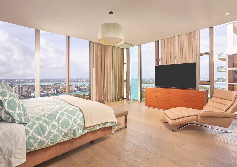 Inspiration for a contemporary bedroom in Miami with light hardwood flooring and no fireplace.
