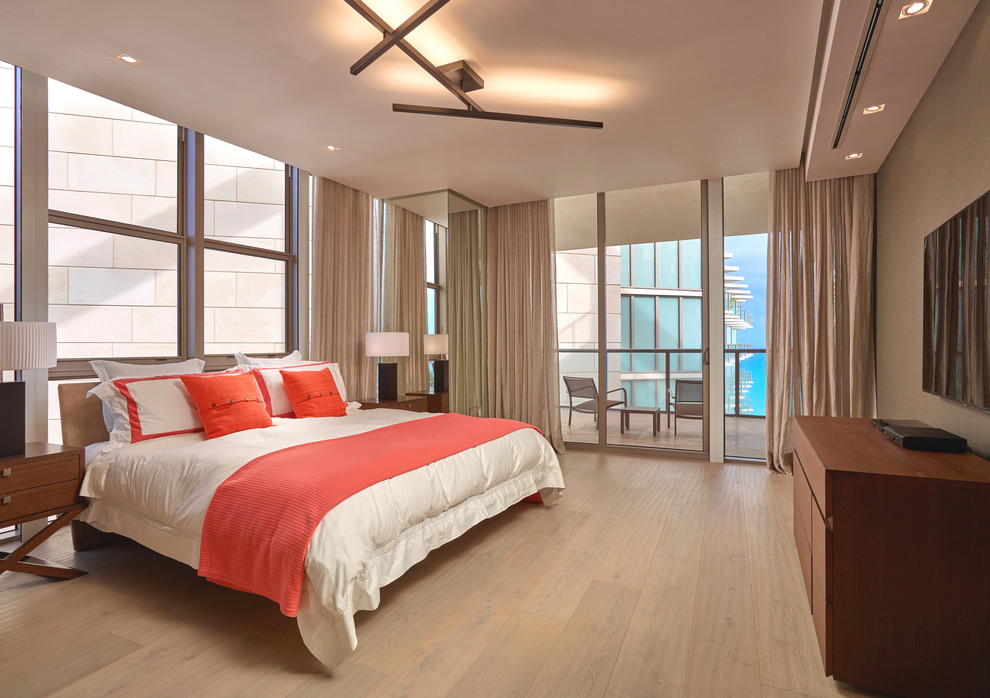 Design ideas for a medium sized contemporary guest bedroom in Miami with beige walls and light hardwood flooring.