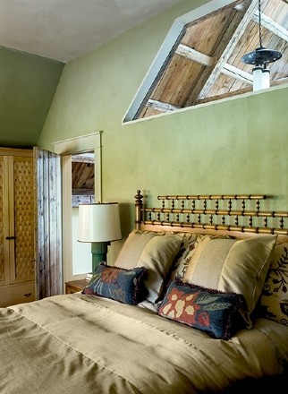 Cette image montre une très grande chambre chalet avec un mur vert, aucune cheminée et un sol beige.