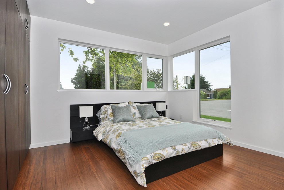 Diseño de habitación de invitados moderna de tamaño medio sin chimenea con paredes blancas y suelo de madera en tonos medios