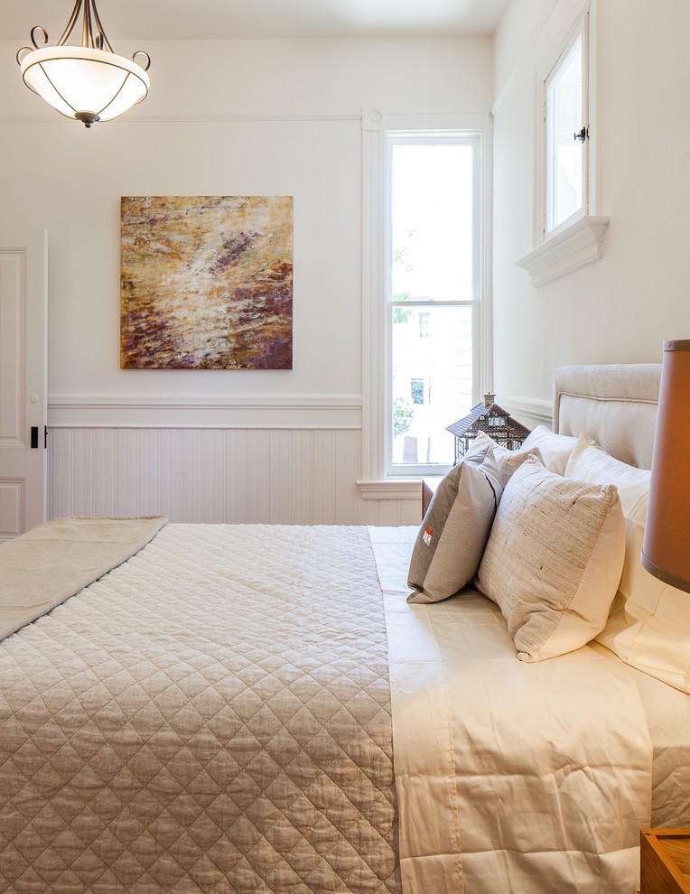 Ejemplo de dormitorio principal tradicional de tamaño medio con paredes blancas y suelo de madera en tonos medios