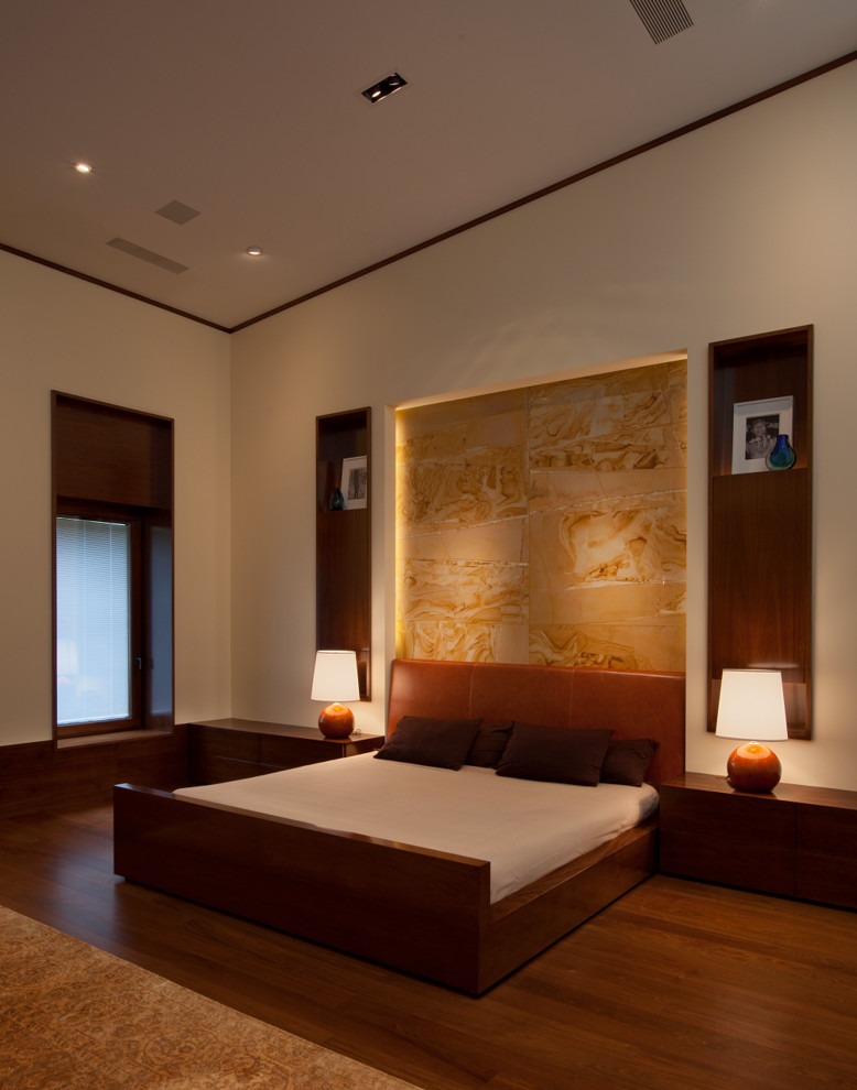 Contemporary master bedroom in New York with beige walls and medium hardwood flooring.