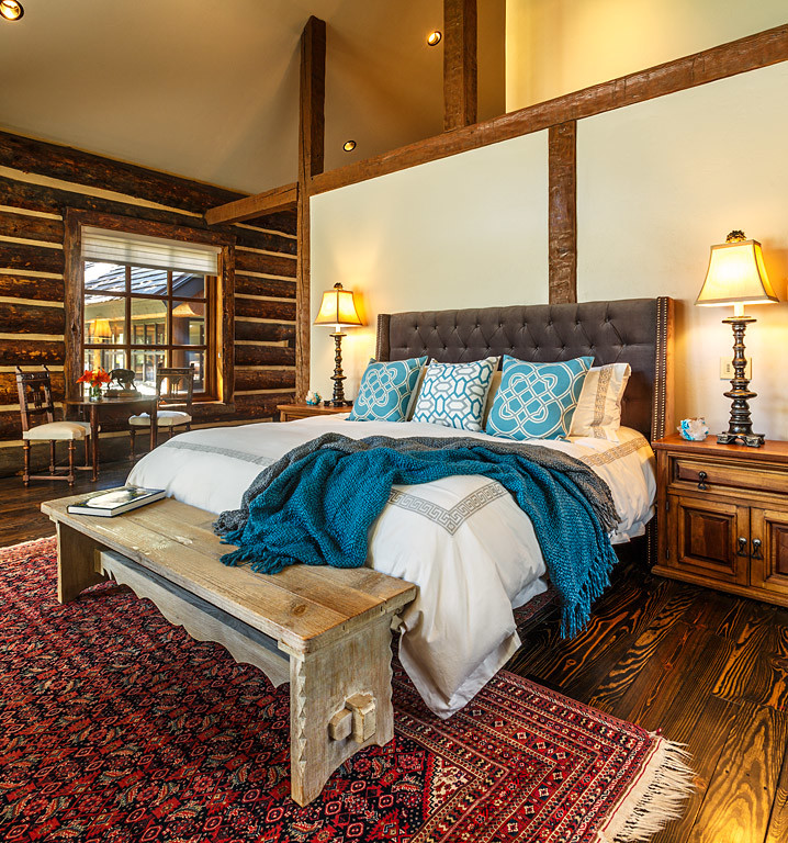 Bedroom - large rustic master medium tone wood floor bedroom idea in Albuquerque with gray walls, a standard fireplace and a stone fireplace