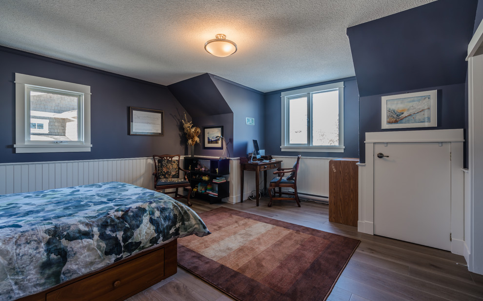 Modelo de dormitorio tradicional de tamaño medio con paredes azules, suelo de madera en tonos medios y suelo marrón