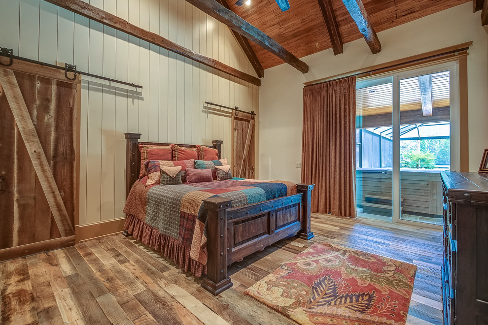 This is an example of a rustic master bedroom in Atlanta with white walls, medium hardwood flooring and no fireplace.