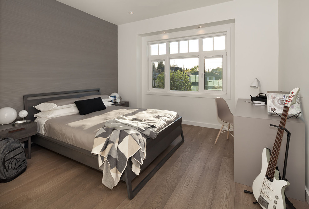 Aménagement d'une chambre moderne de taille moyenne avec un mur gris et un sol en bois brun.