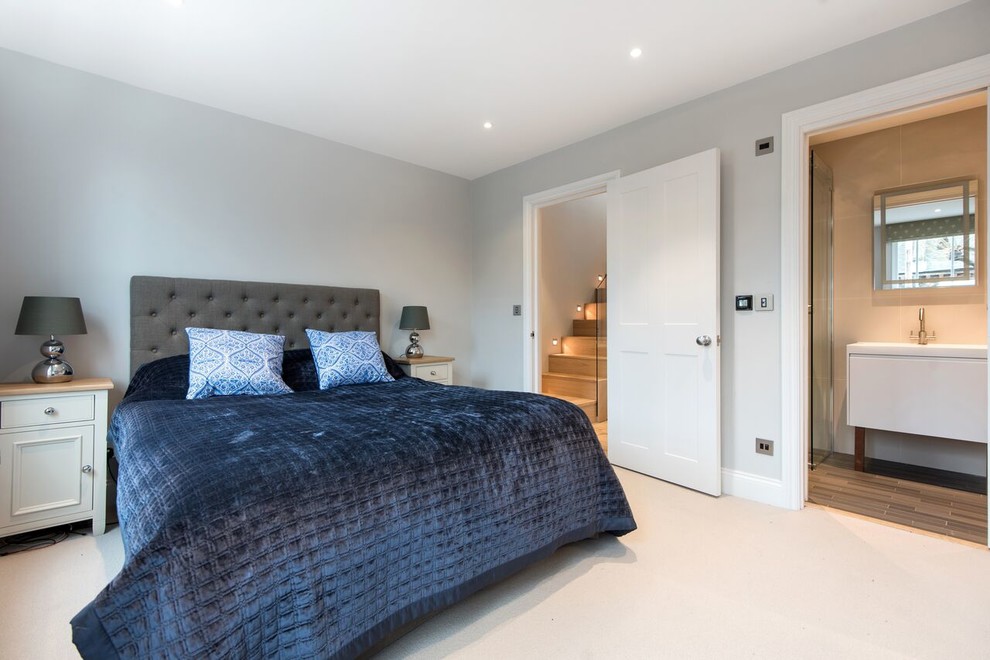Medium sized contemporary bedroom in London with grey walls, carpet and beige floors.