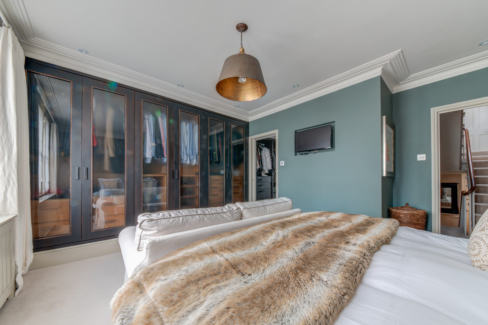 Modelo de dormitorio principal contemporáneo grande con paredes verdes, moqueta y suelo beige