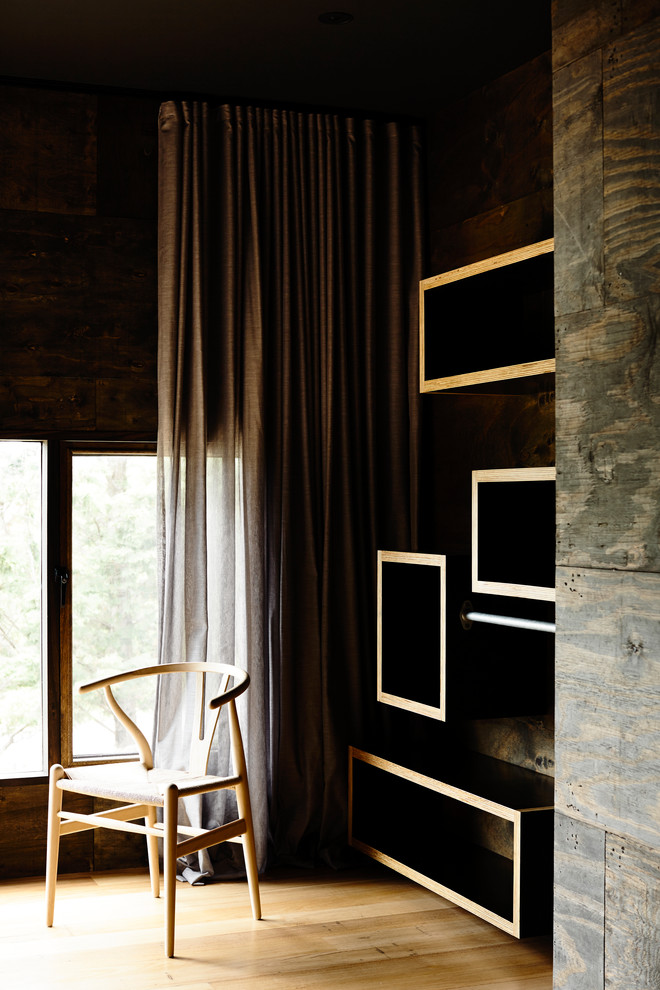 Modelo de habitación de invitados actual de tamaño medio con paredes negras y suelo de madera en tonos medios