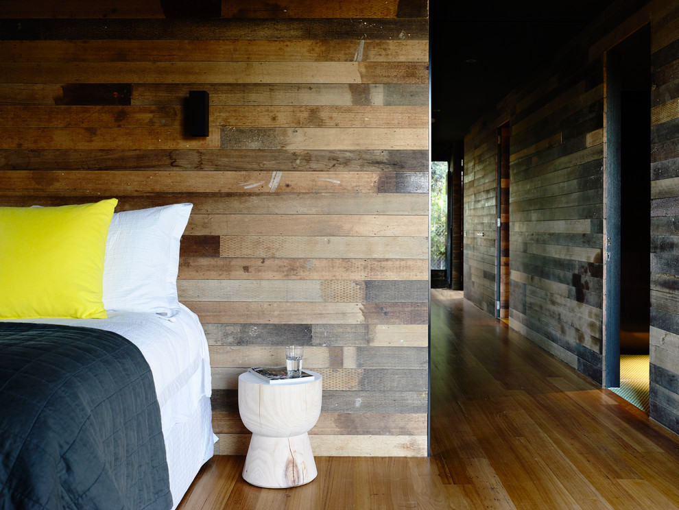 Idées déco pour une chambre d'amis contemporaine de taille moyenne avec un mur noir et un sol en bois brun.