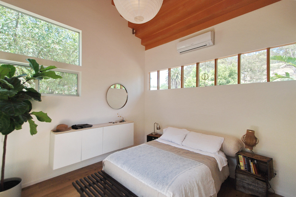 Diseño de dormitorio contemporáneo de tamaño medio con paredes blancas, suelo de madera oscura y suelo marrón