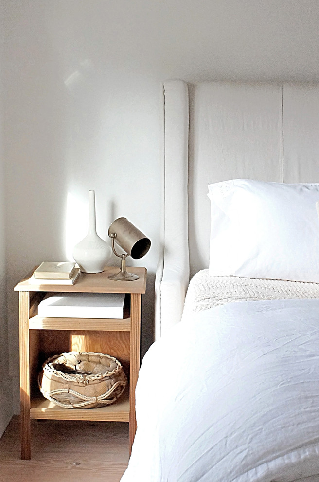 Imagen de dormitorio principal clásico renovado de tamaño medio con paredes blancas y suelo de madera clara