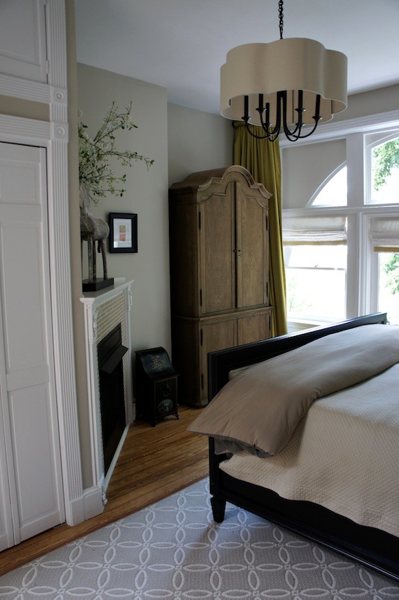 Ejemplo de dormitorio principal clásico pequeño con paredes grises, suelo de madera clara, chimenea de esquina y marco de chimenea de baldosas y/o azulejos