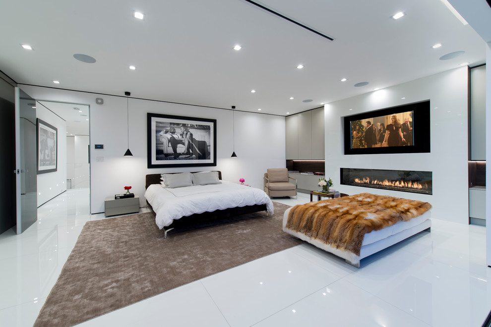 Contemporary grey and silver bedroom in Los Angeles with white walls and a ribbon fireplace.